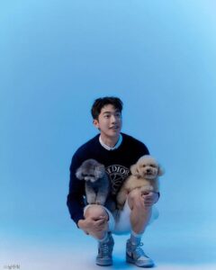 Smiling person crouching with two dogs.
