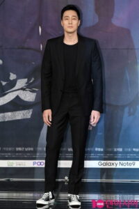 Man in black suit and sneakers at event.