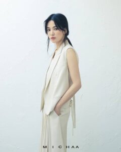 Elegant woman in beige outfit against white background.