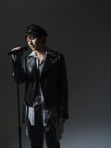 Person singing into a microphone on stage.