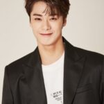 Smiling person in a black blazer.