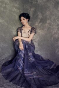 Elegant woman in a flowing purple gown.