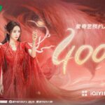 Woman in red dress with dramatic background.