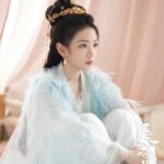 Woman in elegant attire with feather details.