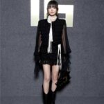 Person in fashionable black outfit with bag.