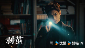 Man holding flashlight in dark library.