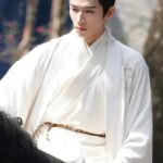 Man in traditional attire riding a horse.