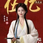 Woman in traditional attire holding calligraphy brush.