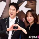 Smiling couple making heart with hands.