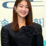 Smiling woman in elegant black outfit.