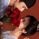 Period drama couple with red roses.
