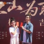 Two people posing with red envelopes.