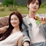 Smiling couple outdoors with perfume bottle.