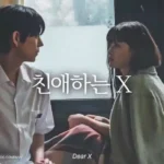 Two people sitting by a window.