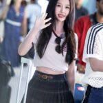 Person waving while standing at airport.