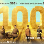 People standing in front of large straw numbers.