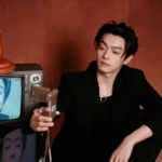 Person taking selfie with vintage TV.