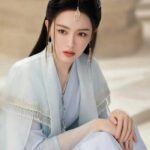 Woman in traditional attire with ornate headpiece.