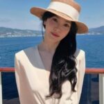 Woman in white dress wearing straw sunhat